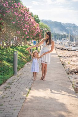 Mutlu anne-kız çocuğu marinada lüks yatlarda eğleniyor. Aile seyahati, yaşam tarzı, tatil konsepti. Yüksek kalite fotoğraf