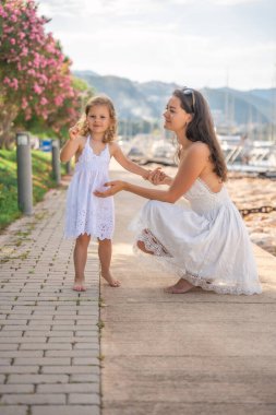 Mutlu anne-kız çocuğu marinada lüks yatlarda eğleniyor. Aile seyahati, yaşam tarzı, tatil konsepti. Yüksek kalite fotoğraf
