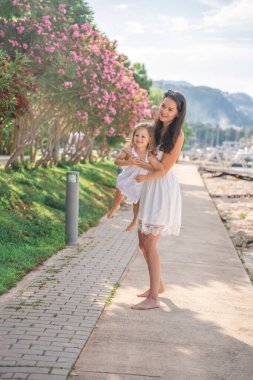 Mutlu anne-kız çocuğu marinada lüks yatlarda eğleniyor. Aile seyahati, yaşam tarzı, tatil konsepti. Yüksek kalite fotoğraf