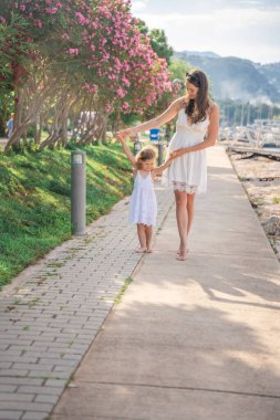 Mutlu anne-kız çocuğu marinada lüks yatlarda eğleniyor. Aile seyahati, yaşam tarzı, tatil konsepti. Yüksek kalite fotoğraf