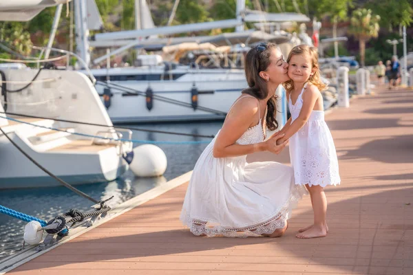 Mutlu anne-kız çocuğu marinada lüks yatlarda eğleniyor. Aile seyahati, yaşam tarzı, tatil konsepti. Yüksek kalite fotoğraf