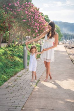Mutlu anne-kız çocuğu marinada lüks yatlarda eğleniyor. Aile seyahati, yaşam tarzı, tatil konsepti. Yüksek kalite fotoğraf