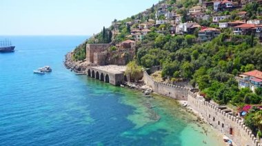 Türkiye 'nin Alanya kentindeki Kizil Kule kulesi yakınlarındaki antik tersane veya Tersane ve güzel plaj ve sakin turkuaz deniz yüzeyi. Yüksek kalite 4k görüntü