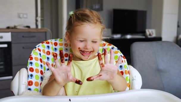 Kleines Mädchen Mit Blonden Haaren Isst Hausgemachte Schokolade Und Zeigt — Stockvideo