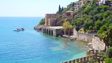 Türkiye 'nin Alanya kentindeki Kizil Kule kulesi yakınlarındaki antik tersane veya Tersane ve güzel plaj ve sakin turkuaz deniz yüzeyi. Yüksek kalite 4k görüntü