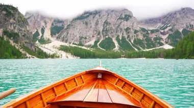 Dolomitler, Güney Tyrol, İtalya 'daki manzaralı Lago di Braies' de geleneksel ahşap kayık. Yüksek kalite 4k görüntü