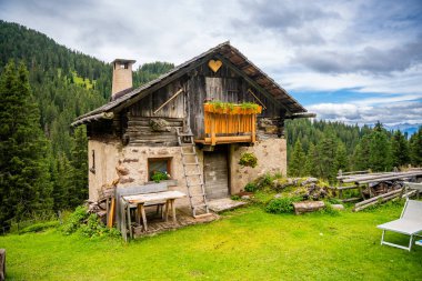 Puez Odle Doğa Parkı 'ndaki Dolomite manzarası. Alp yaylalarından ahşap evler ve yeşil çayırlar görünüyor. Yüksek kalite fotoğraf