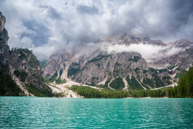 Braies gölü, İtalya 'nın bulutlu bir gününde çam ormanları ve Dolomitlerin kayalık dağlarıyla çevrilidir. Yüksek kalite fotoğraf