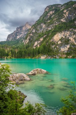 Braies gölü, İtalya 'nın bulutlu bir gününde çam ormanları ve Dolomitlerin kayalık dağlarıyla çevrilidir. Yüksek kalite fotoğraf