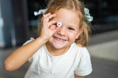 Küçük kız boncukla oynuyor. Tahta boncuk bileziği yapıyor. Çocukların yaratıcılığı ve iyi motor becerilerin gelişimi. Yüksek kalite fotoğraf