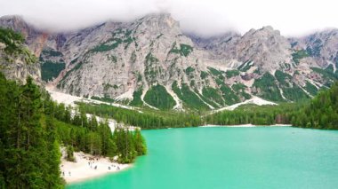 Braies gölü, İtalya 'nın bulutlu bir gününde çam ormanları ve Dolomitlerin kayalık dağlarıyla çevrilidir. Yüksek kalite 4k görüntü