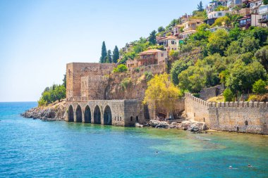Türkiye 'nin Alanya kentindeki Kizil Kule kulesi yakınlarındaki antik tersane veya Tersane ve güzel plaj ve sakin turkuaz deniz yüzeyi. Yüksek kalite fotoğraf