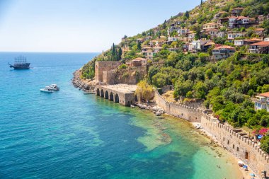 Türkiye 'nin Alanya kentindeki Kizil Kule kulesi yakınlarındaki antik tersane veya Tersane ve güzel plaj ve sakin turkuaz deniz yüzeyi. Yüksek kalite fotoğraf