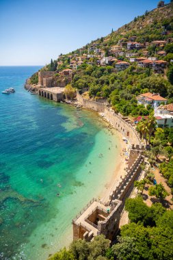 Türkiye 'nin Alanya kentindeki Kizil Kule kulesi yakınlarındaki antik tersane veya Tersane ve güzel plaj ve sakin turkuaz deniz yüzeyi. Yüksek kalite fotoğraf