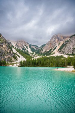 Braies gölü, İtalya 'nın bulutlu bir gününde çam ormanları ve Dolomitlerin kayalık dağlarıyla çevrilidir. Yüksek kalite fotoğraf