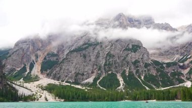 Braies gölü, İtalya 'nın bulutlu bir gününde çam ormanları ve Dolomitlerin kayalık dağlarıyla çevrilidir. Yüksek kalite 4k görüntü