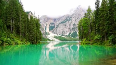 Braies gölü, İtalya 'nın bulutlu bir gününde çam ormanları ve Dolomitlerin kayalık dağlarıyla çevrilidir. Yüksek kalite 4k görüntü