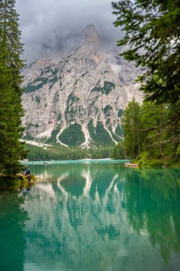 Braies gölü, İtalya 'nın bulutlu bir gününde çam ormanları ve Dolomitlerin kayalık dağlarıyla çevrilidir. Yüksek kalite fotoğraf