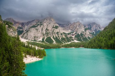 Braies gölü, İtalya 'nın bulutlu bir gününde çam ormanları ve Dolomitlerin kayalık dağlarıyla çevrilidir. Yüksek kalite fotoğraf