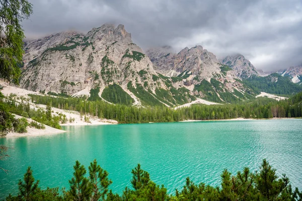 Braies gölü, İtalya 'nın bulutlu bir gününde çam ormanları ve Dolomitlerin kayalık dağlarıyla çevrilidir. Yüksek kalite fotoğraf