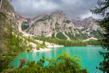 Braies gölü, İtalya 'nın bulutlu bir gününde çam ormanları ve Dolomitlerin kayalık dağlarıyla çevrilidir. Yüksek kalite fotoğraf