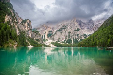Braies gölü, İtalya 'nın bulutlu bir gününde çam ormanları ve Dolomitlerin kayalık dağlarıyla çevrilidir. Yüksek kalite fotoğraf