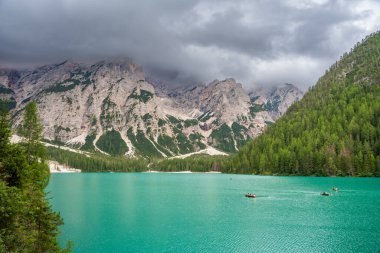 Braies gölü, İtalya 'nın bulutlu bir gününde çam ormanları ve Dolomitlerin kayalık dağlarıyla çevrilidir. Yüksek kalite fotoğraf