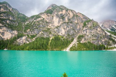 Braies gölü, İtalya 'nın bulutlu bir gününde çam ormanları ve Dolomitlerin kayalık dağlarıyla çevrilidir. Yüksek kalite fotoğraf