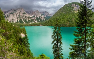 Braies gölü, İtalya 'nın bulutlu bir gününde çam ormanları ve Dolomitlerin kayalık dağlarıyla çevrilidir. Yüksek kalite fotoğraf