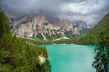 Braies gölü, İtalya 'nın bulutlu bir gününde çam ormanları ve Dolomitlerin kayalık dağlarıyla çevrilidir. Yüksek kalite fotoğraf