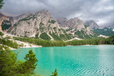 Braies gölü, İtalya 'nın bulutlu bir gününde çam ormanları ve Dolomitlerin kayalık dağlarıyla çevrilidir. Yüksek kalite fotoğraf