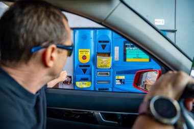 Güney Tyrol, İtalya - 3 Ağustos 2023: Otoyol veya Otomatik Ticaret için bir İtalyan gişesinde kart ile ödeme yapan bir adam. Yüksek kalite fotoğraf