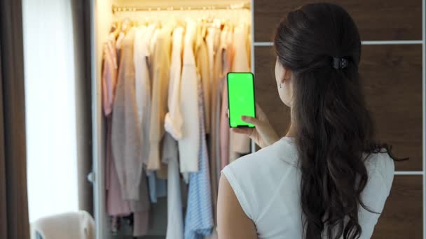年轻女性使用智能手机应用来销售应用程序中的旧衣服 彩色绿色屏幕 高质量的4K镜头 — 图库视频影像