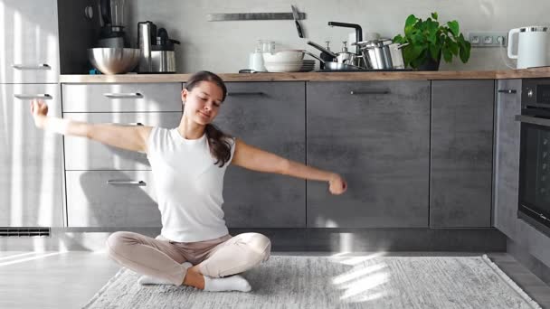 若い幸せな女性はキッチンで汚れた料理の背景に座っています スローダウン セルフケア スローライフコンセプト 高品質の写真 — ストック動画