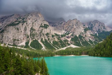 Braies gölü, İtalya 'nın bulutlu bir gününde çam ormanları ve Dolomitlerin kayalık dağlarıyla çevrilidir. Yüksek kalite fotoğraf