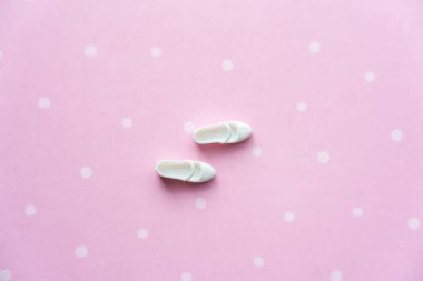 Pembe arka planda beyaz bebek ayakkabıları. Yüksek kalite fotoğraf