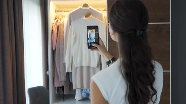 年轻女子在智能手机应用程序中拍摄旧的不受欢迎的衣服 高质量的4K镜头 — 图库视频影像