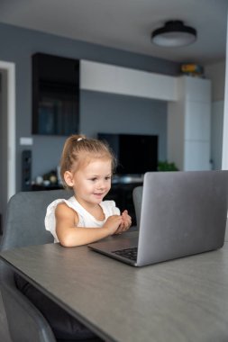 Küçük kız dizüstü bilgisayarında parmak jimnastiği yapıyor. Uzaktan öğrenme konsepti. Yüksek kalite fotoğraf