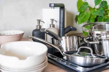 Kirli bulaşıklar ve yıkanmamış mutfak aletleri mutfak lavabosunu doldurdu. Yüksek kalite fotoğraf