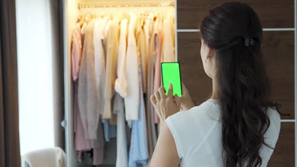 年轻女性使用智能手机应用来销售应用程序中的旧衣服 彩色绿色屏幕 高质量的4K镜头 — 图库视频影像