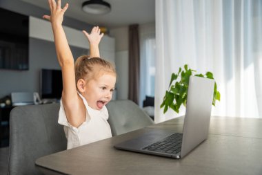 Küçük kız dizüstü bilgisayarında parmak jimnastiği yapıyor. Uzaktan öğrenme konsepti. Yüksek kalite fotoğraf