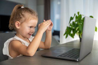 Küçük kız dizüstü bilgisayarında parmak jimnastiği yapıyor. Uzaktan öğrenme konsepti. Yüksek kalite fotoğraf