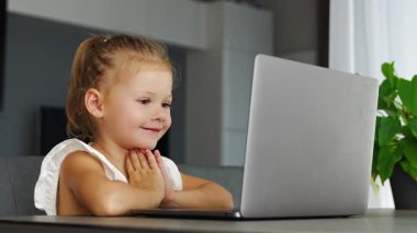 Küçük kız dizüstü bilgisayarında parmak jimnastiği yapıyor. Uzaktan öğrenme konsepti. Yüksek kalite 4k görüntü
