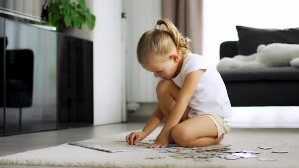 Little Blonde Girl Sits Home Carpet Collects Puzzles High Quality — Stock Video