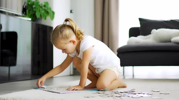 Petite Fille Blonde Assoit Maison Sur Tapis Recueille Des Puzzles — Video