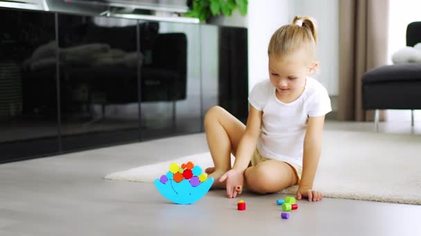 Mała Dziewczynka Bawiąca Się Drewnianą Zabawką Balansowania Podłodze Salonie Wysokiej — Wideo stockowe