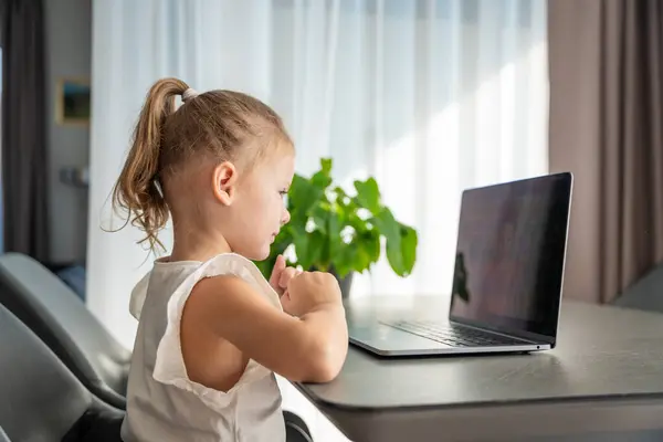 Little girl student online learning, class study online video call with teacher on the laptop home. Distance learning concept. High quality photo