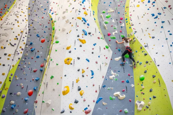 布拉格体育中心室内攀岩的年轻女子挂在彩色钩子上攀爬人造墙 极限运动和巨石的概念 高质量的照片 — 图库照片