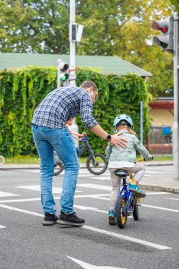 Mutlu aile babası, Çek Cumhuriyeti 'nin Prag kentindeki trafik parkında çocuk kızına bisiklet sürmeyi öğretiyor. Yüksek kalite fotoğraf