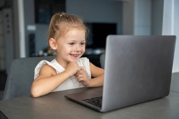 Little girl student online learning, class study online video call with teacher on the laptop home. Distance learning concept. High quality photo